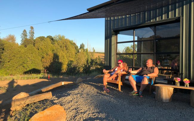 Two people sitting in adirondack chairs outside of the Bellingar Estate tasting room